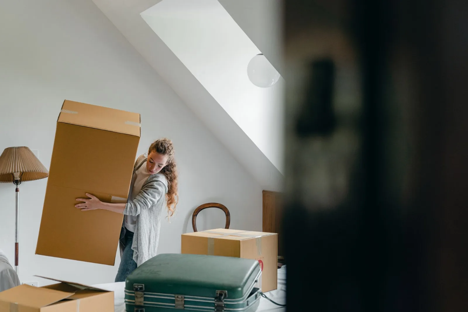 A person carrying cardboard cartons while moving to a new place