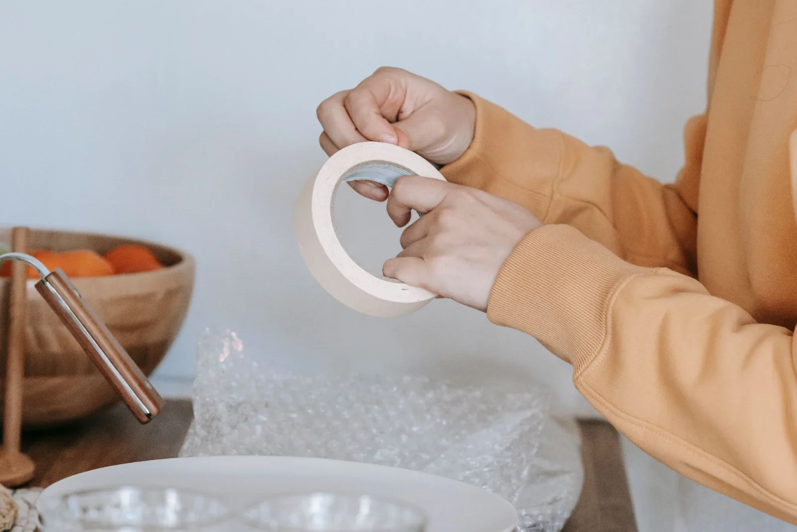 A woman preparing to pack dishes and glassware from a kitchen before a move