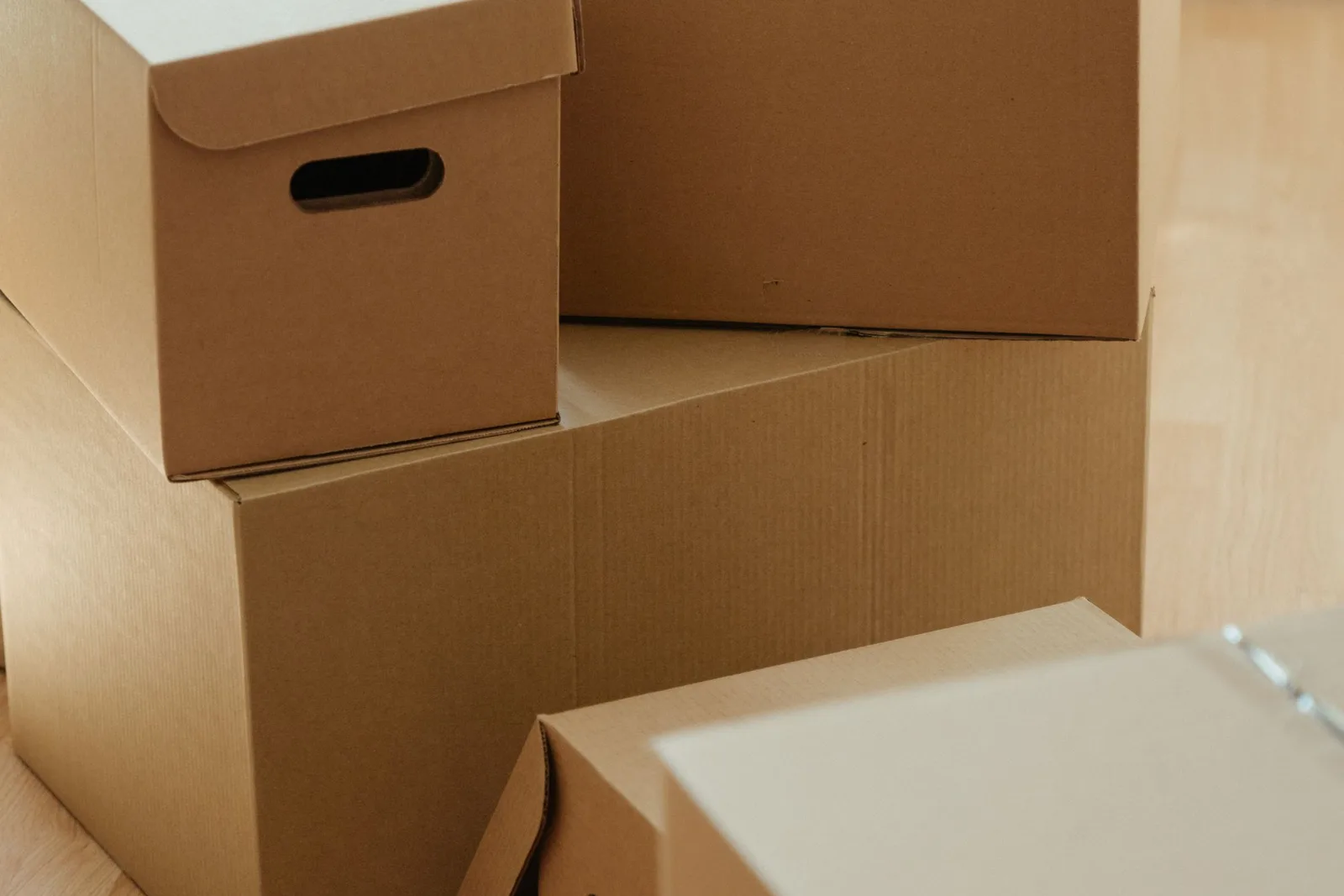 Cardboard cartons stacked on a wooden floor ready to be moved