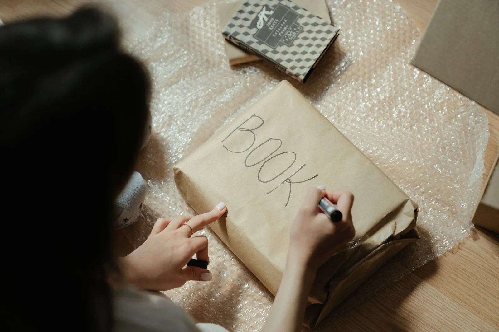A person wrapping items in bubble wrap and kraft paper for safe transport